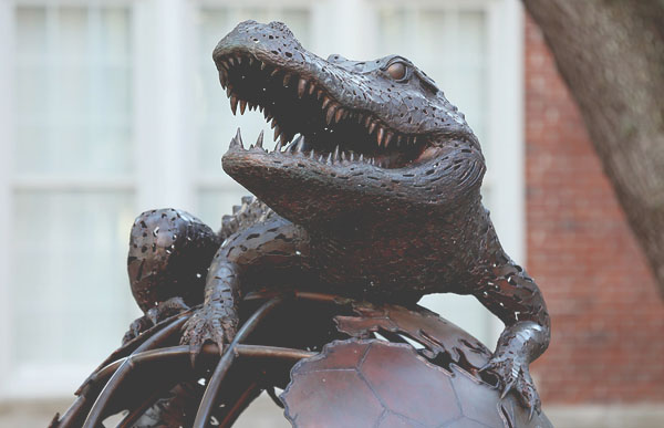 Photo of the Gator Ubiquity statue - a bronze gator on top of a wirefiramed globe.